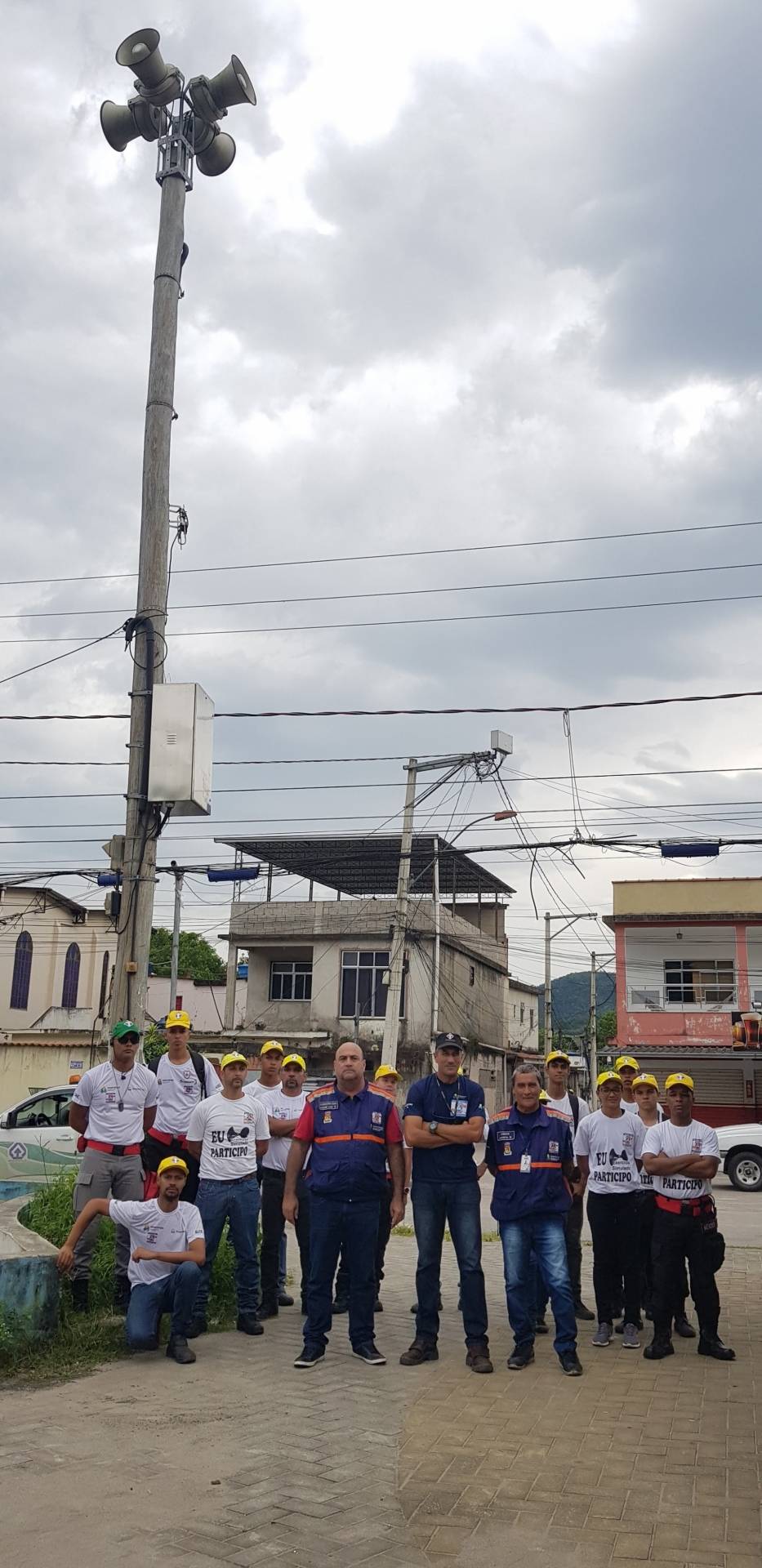 Funcionários posam ao lado de uma das sirenes instaladas pela Prefeitura 