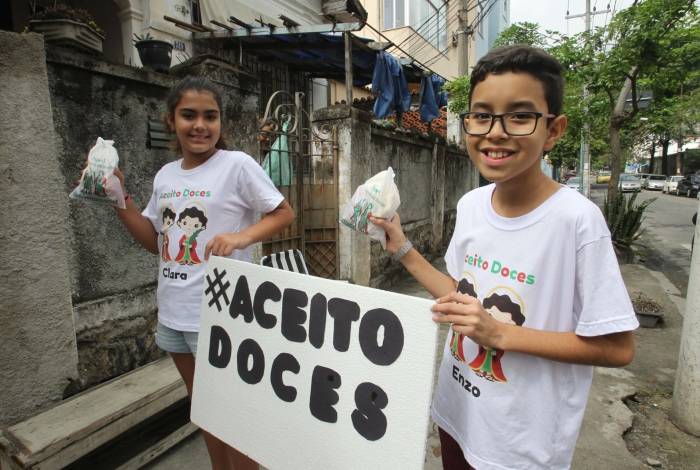 Crianças exibem cartaz pelas ruas da Zona Norte pedindo doces