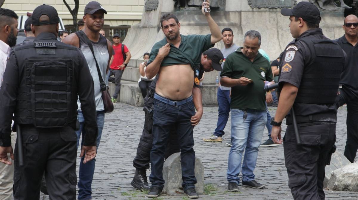 Policial revista manifestante