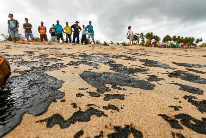 No litoral de Alagoas, um grupo de trabalho retira óleo da praia 