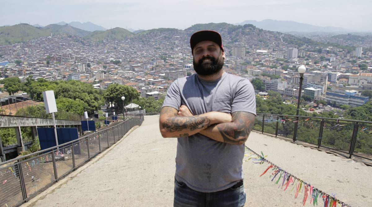 Rio,29/10/2019 -Penha-- Roteiro do  Suburbio,Tour com o dono da pagina Suburbano da Depressao. Na foto,Vitor Almeida, com morro do Alemao ao fundo .Foto: Cléber Mendes/Agência O Dia