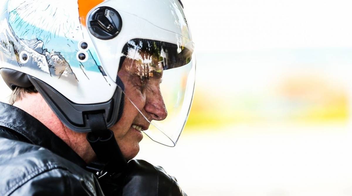 O presidente Jair Bolsonaro chega de moto no Palácio da Alvorada e cumprimenta turistas