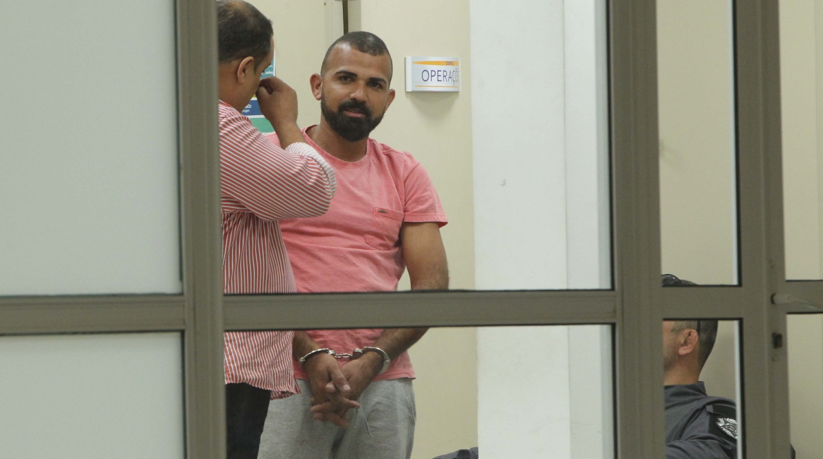 Presos na opera&ccedil;&atilde;o CERBERUS, em Caxias chegam &auml; Cidade da Policia. Na foto, um dos presos, de camisa rosa conversa com inspetores.     
      Byline