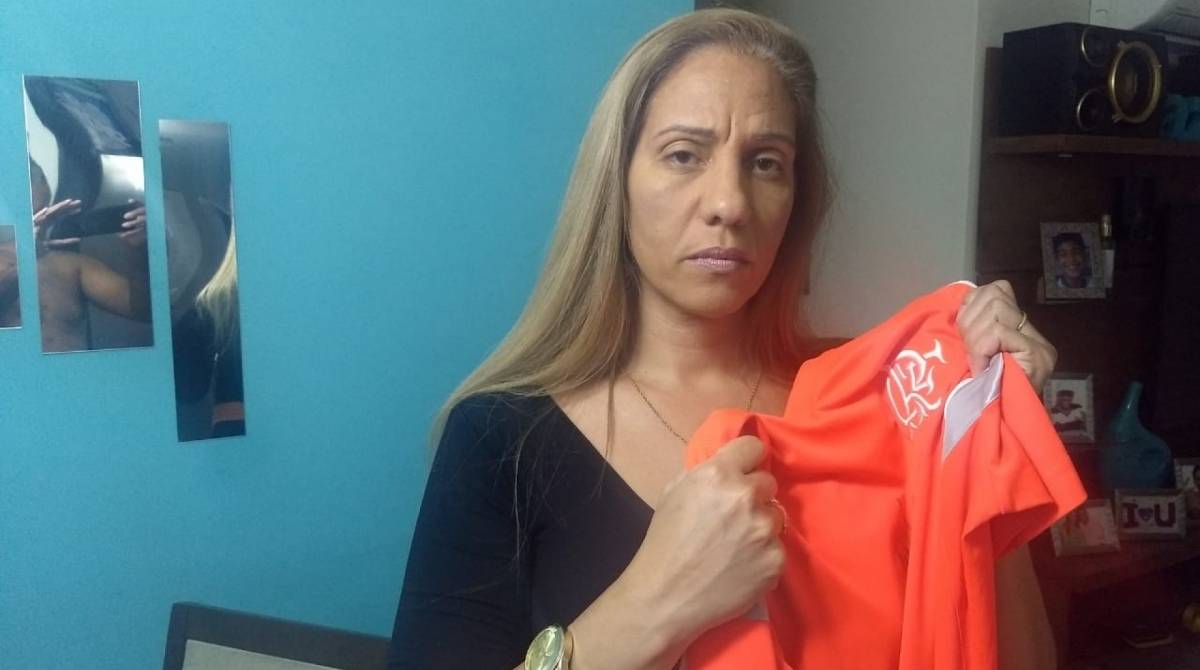 Luciana Fortuna teve o filho preso injustamente. Na foto, ela segura uma camisa do filho. Ela chegou a levar roupas limpas para a audiência pois acreditava que ele ficaria livre - Divulgação