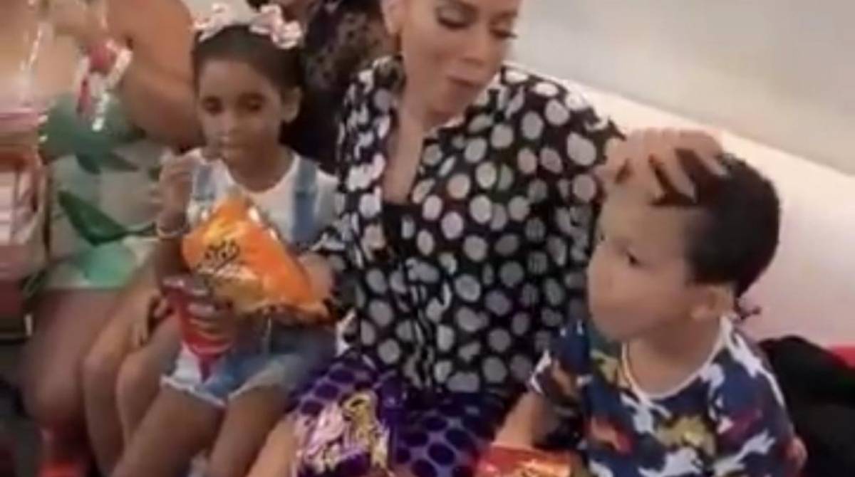 Anitta com a mão suja de salgadinho no cabelo do sobrinho  - reprodução Instagram