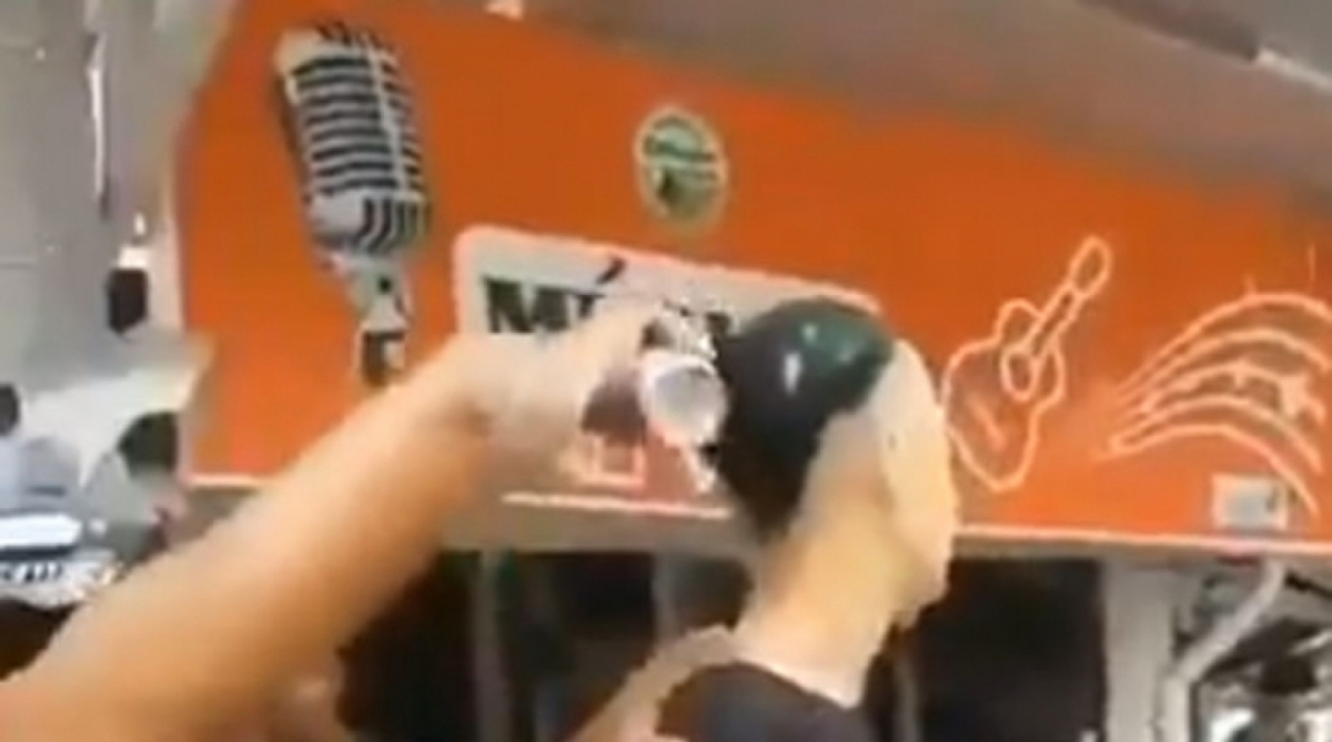 Homem, que seria ligado à milícia, aplica spray com tinta preta no cabelo descolorido de adolescente - Reprodução vídeo / WhatsApp O DIA (98762-8248)