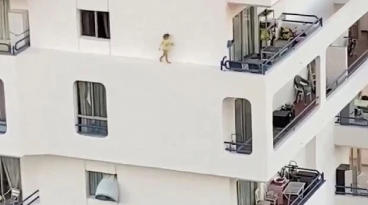 Criança cruza parapeito externo de prédio - Reprodução