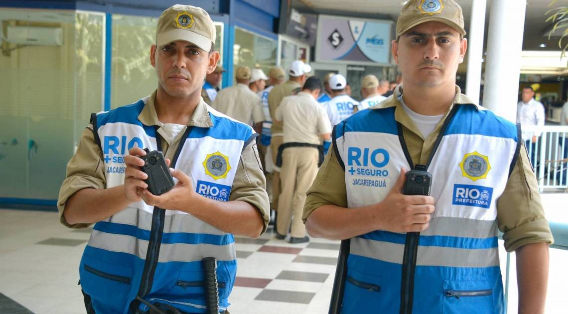 Agentes do Rio Seguro exibem as microcâmeras e a forma como serão acopladas ao uniforme durante as ações de teste em Jacarepaguá - Marco Antônio Rezende