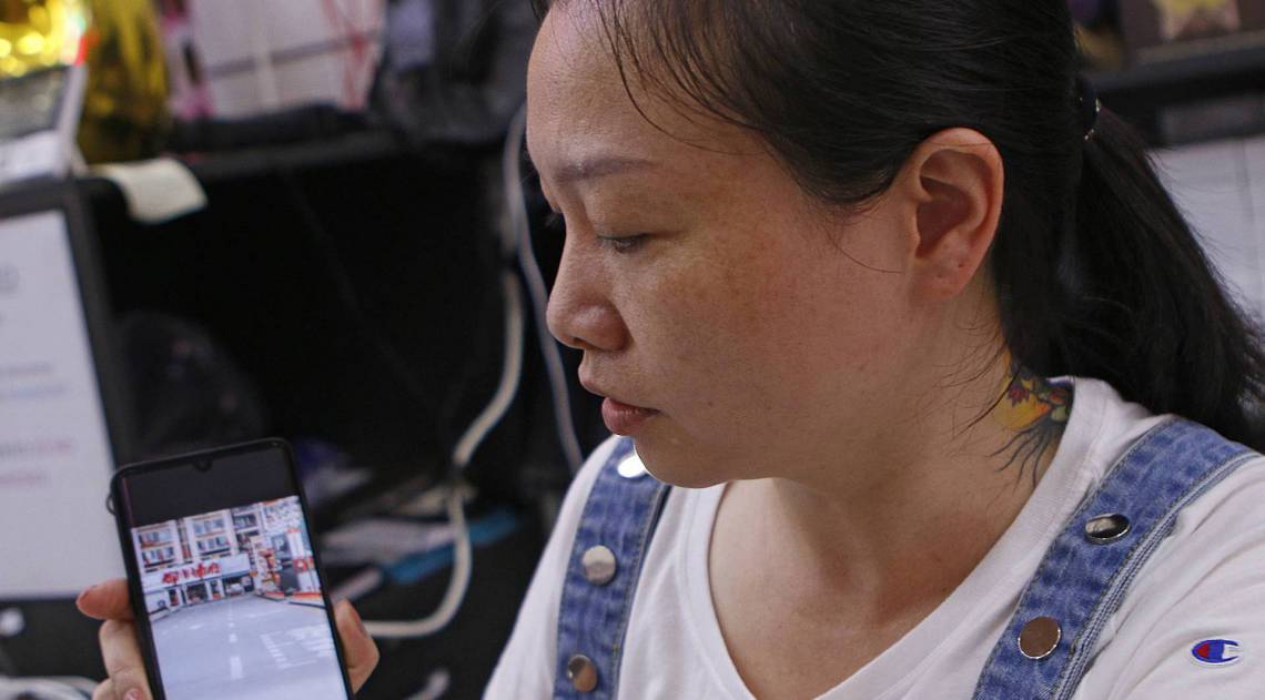 A comerciante Zhang mostra imagens da sua cidade natal na China: as ruas l&aacute; est&atilde;o vazias 