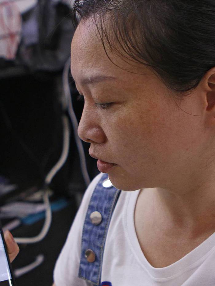 A comerciante Zhang mostra imagens da sua cidade natal na China: as ruas l&aacute; est&atilde;o vazias 