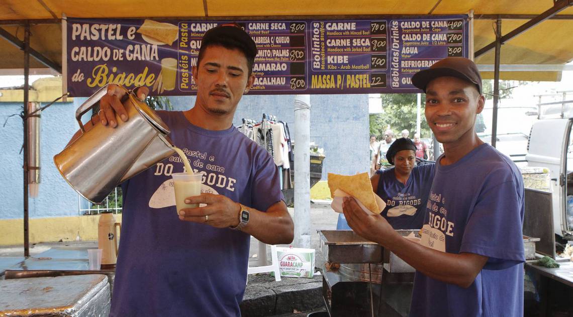 Rio de Janeiro - RJ - 07/02/2020 - Regulamentaçao do comercio de Caldo de Cana e Pastel na cidade - na foto, Diego dos Santos Viana, servindo caldo de cana e Jose Maria, funcionarios da barraca do Bigode, na Feira na Rua Engenheiro Moacir Reis, em Laranjeiras, zona sul do Rio - Foto Reginaldo Pimenta / Agencia O Dia