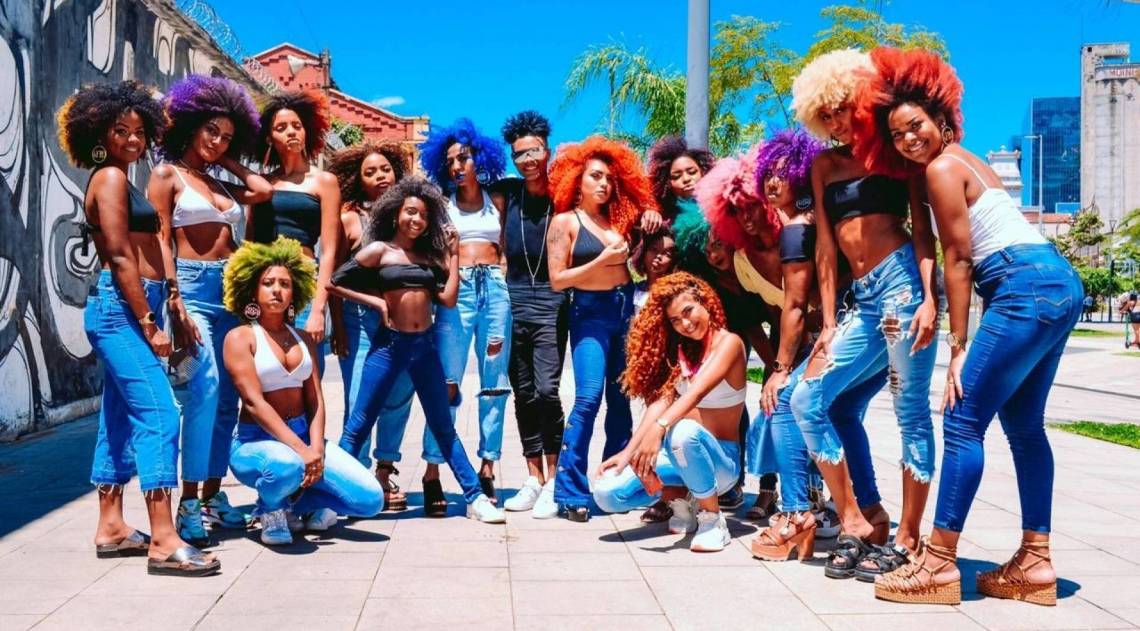 Mestre dos Cachos posa com clientes exibindo os cabelos feitos por ele