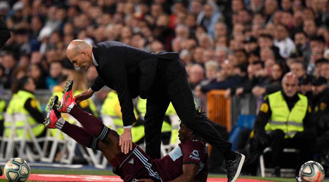 Real Madrid's French coach Zinedine Zidane (up) collides with Celta Vigo's Ghanaian defender Joseph Aidoo (down) during the Spanish league football match between Real Madrid CF and RC Celta de Vigo at the Santiago Bernabeu stadium in Madrid on February 16, 2020. (Photo by PIERRE-PHILIPPE MARCOU / AFP)