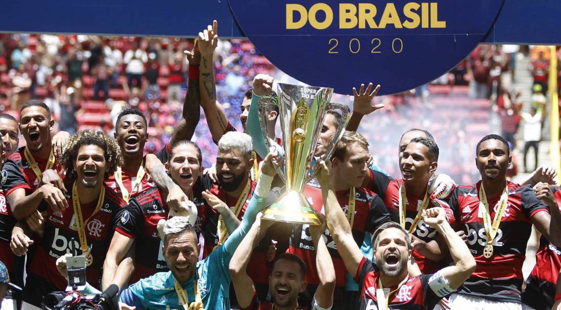 Equipe do Flamengo comemora o título de campeão ao fim da partida contra o Athletico Paranaense, válida pela decisão do título da Supercopa do Brasil 2020, realizada no Estádio Mané Garrincha, em Brasília (DF), neste domingo (16). O Flamengo venceu por 3 a 0. - ADALBERTO MARQUES/ESTADÃO CONTEÚDO