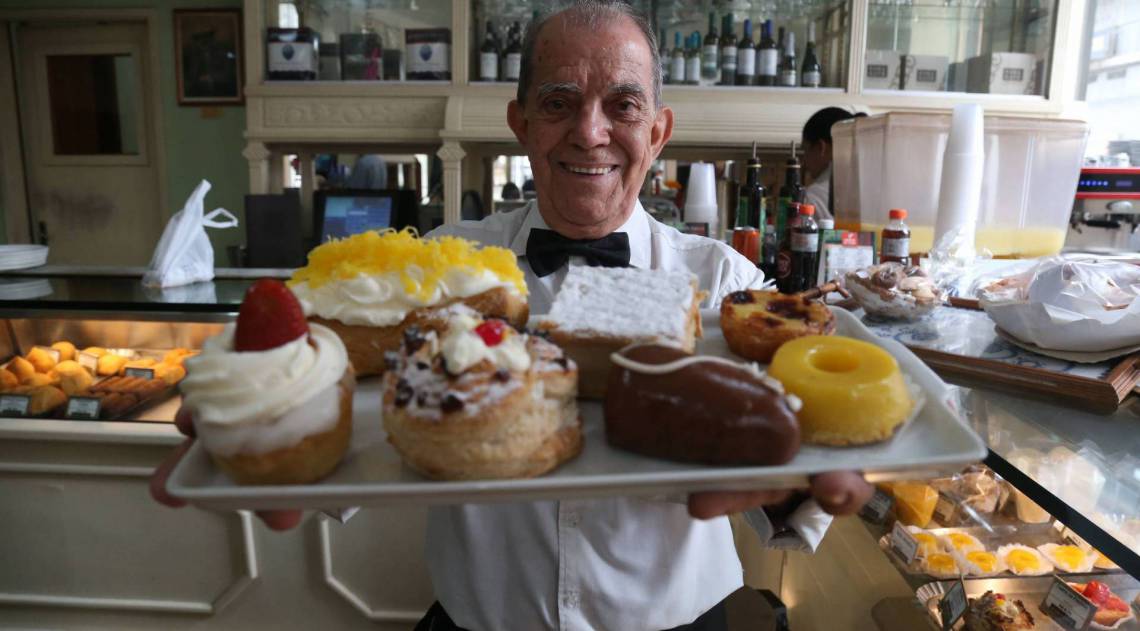 Waldir Ramos, o garçom mais antigo da Casa Cavé, mostra algumas tentações da confeitaria - fotos Cléber Mendes
