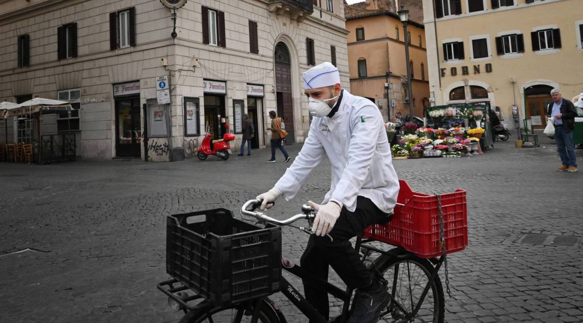 Ruas em Roma estão vazias até de turistas. Quem precisa se locomover, usa máscaras e luvas - AFP