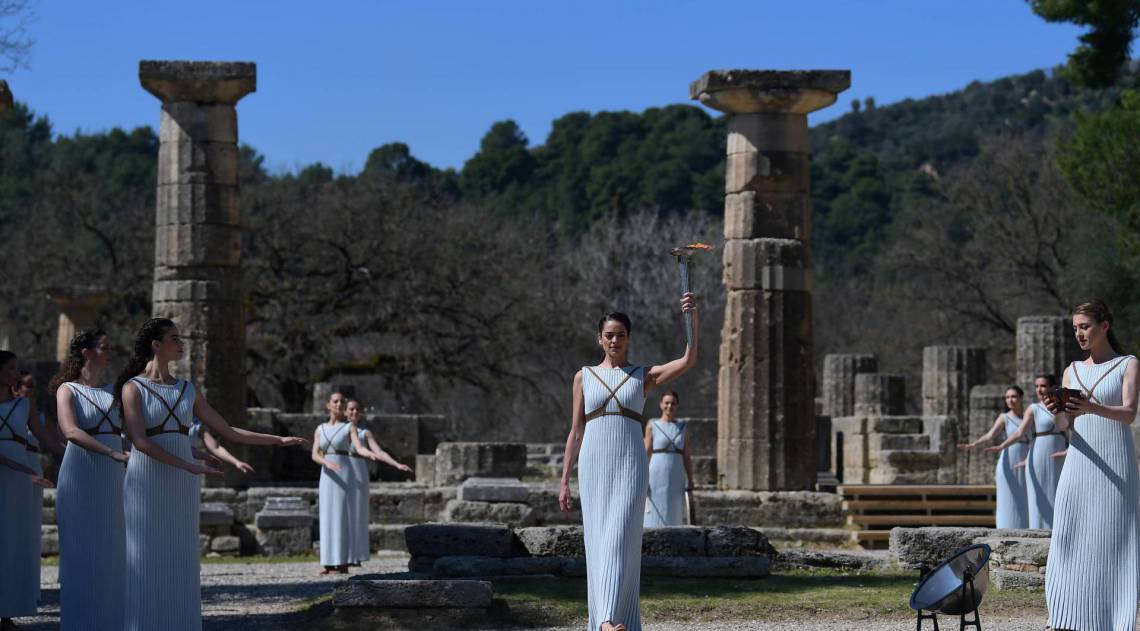 Women dressed as a priestesses take part in the Olympic flame lighting ceremony in ancient Olympia, ahead of Tokyo 2020 Olympic Games on March 12, 2020. (Photo by ARIS MESSINIS / AFP) - AFP