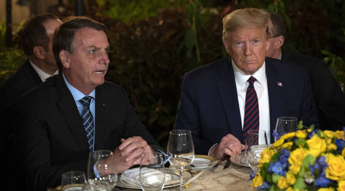 (FILES) In this file photo US President Donald Trump (R) speaks with Brazilian President Jair Bolsonaro during a dinner at Mar-a-Lago in Palm Beach, Florida, on March 7, 2020. - Brazilian President Jair Bolsonaro's press secretary tested positive for coronavirus days after taking part in meetings with President Trump at Mar-a-Lago, Brazilian newspaper O Estado de S. Paulo reported and multiple US outlets have confirmed on March 12, 2020. (Photo by JIM WATSON / AFP)