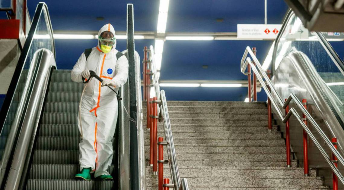 Um membro da empresa NBQ (nuclear, bacteriol&oacute;gica e qu&iacute;mica) da Brigada Guadarrama XII realiza uma desinfec&ccedil;&atilde;o geral na esta&ccedil;&atilde;o de metr&ocirc; Nuevos Ministerios em Madri em 20 de mar&ccedil;o de 2020 (Photo by BALDESCA SAMPER / AFP) - AFP