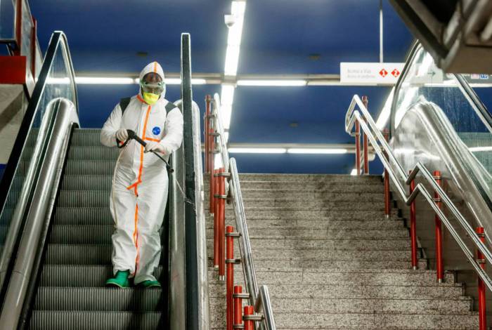 Um membro da empresa NBQ (nuclear, bacteriológica e química) da Brigada 'Guadarrama XII' realiza uma desinfecção geral na estação de metrô Nuevos Ministerios em Madri em 20 de março de 2020 (Photo by BALDESCA SAMPER / AFP)