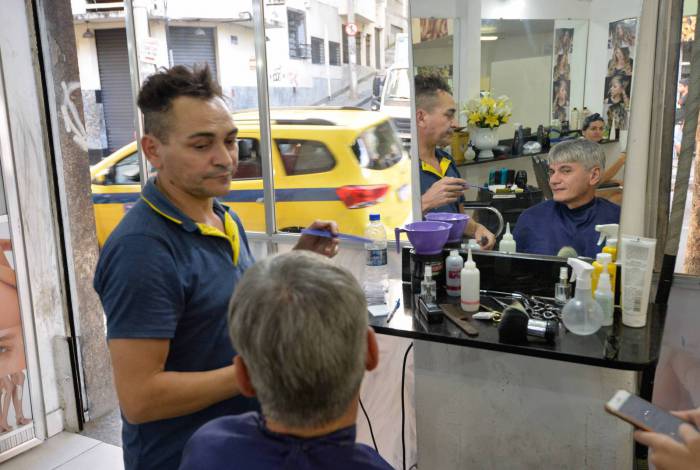 O barbeiro Zequinha e o cliente Belfort: último dia para o corte de cabelo no salão foi ontem
