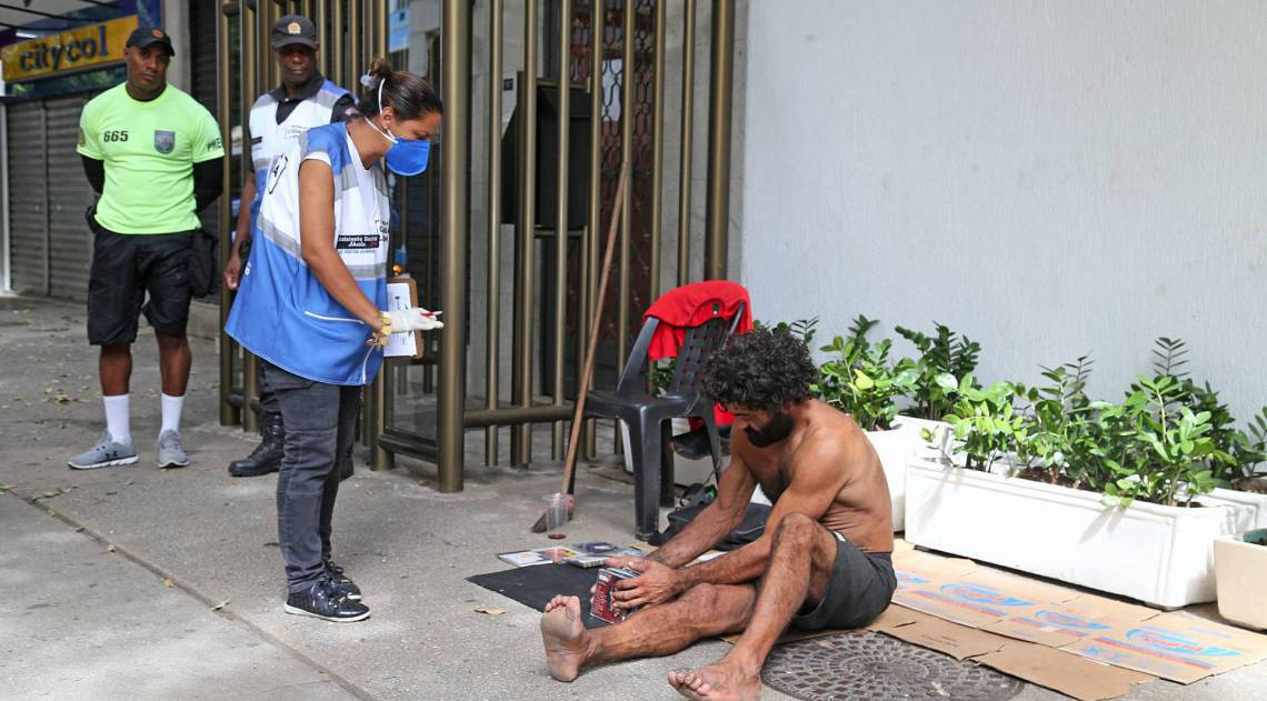 Rio - 24/03/2020 - COVID 19 - CORONAVIRUS - Movimentacao na cidade do Rio no primeiro dia do com&eacute;rcio fechado e restricoes de alguns locais publicos e aglomeracao de pessoas. Copacabana Presente orienta morador de rua a na ficar na calcada da Av. Nossa Senhora de Copacabana.  Foto: Daniel Castelo Branco / Agencia O DIA