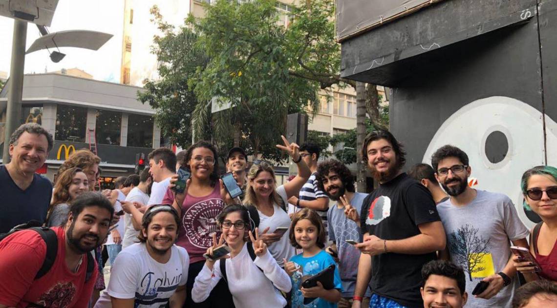 Aline Gomes (ao centro, com dois celulares na mão) e seu grupo de 'Pokémon Go'