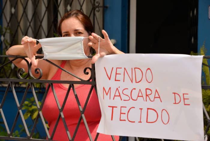 Adriana exibe uma máscara de tecido: R$ 8 a unidade, com faturamento médio de R$ 240 por dia