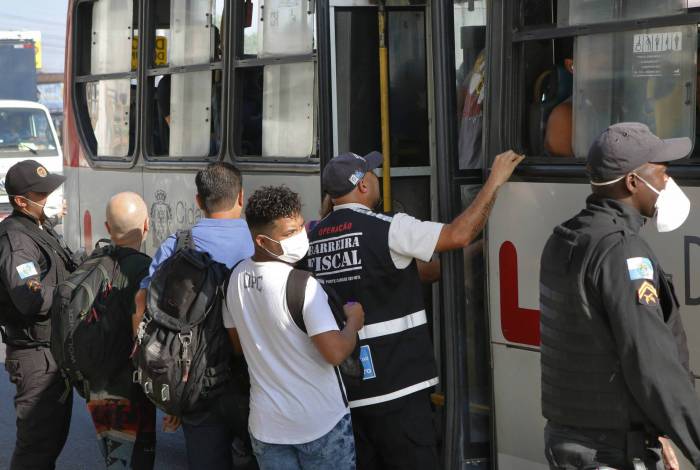 PMs e agentes da operação Barreira Fiscal retiram passageiros que viajavam em pé num ônibus na Av. Brasil