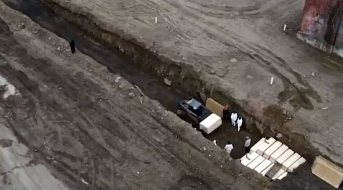 Agentes de sa&uacute;de sepultam v&iacute;timas do novo coronav&iacute;rus em valas coletivas, em Nova York (EUA)