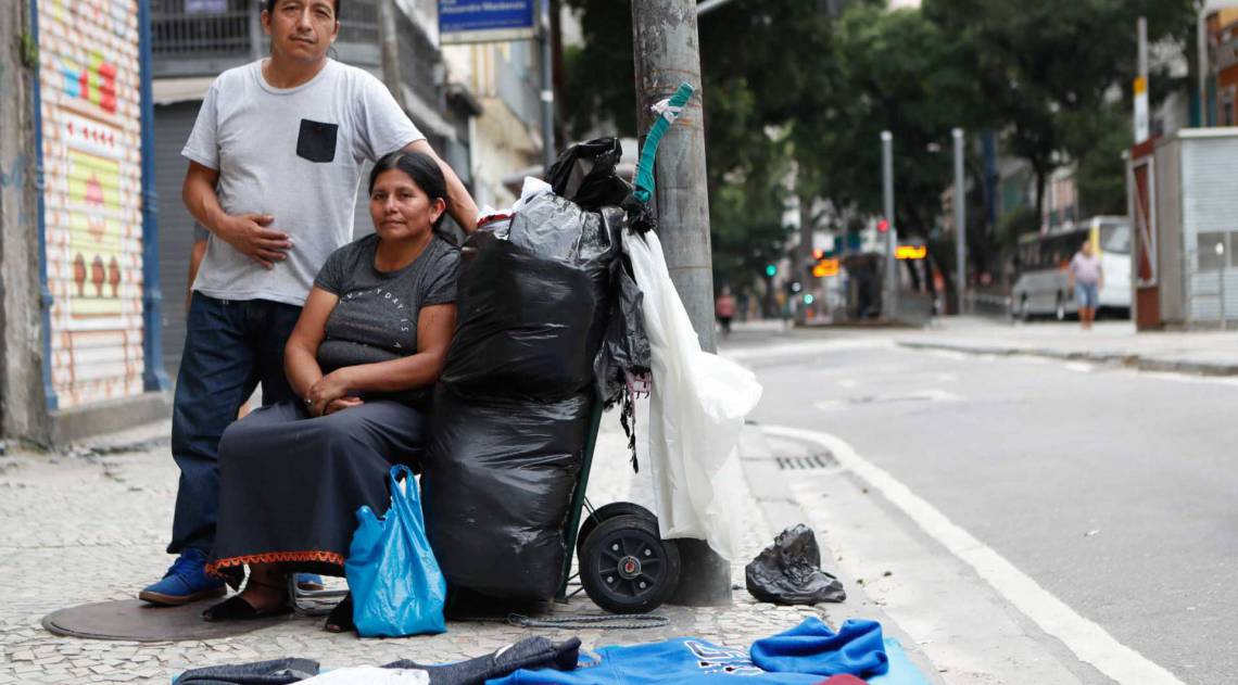 Rio, 07/04/2020 -  Jose Isama e a sua esposa, Maria Tocagon, tentam vender seus produtos nas ruas vazias do centro do Rio