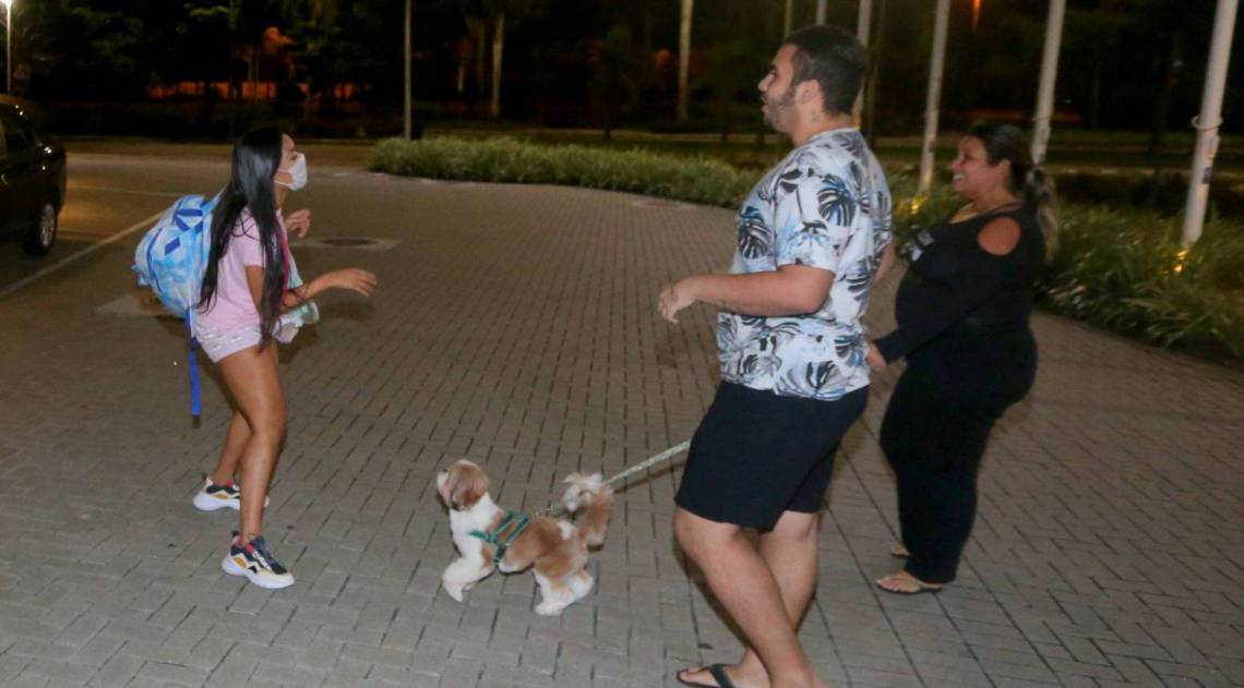 Flay chega ao hotel de máscara e posa com fãs