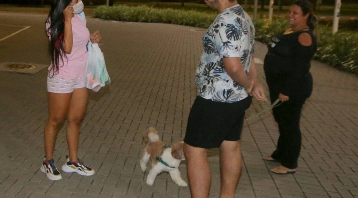 Flay chega ao hotel de máscara e posa com fãs