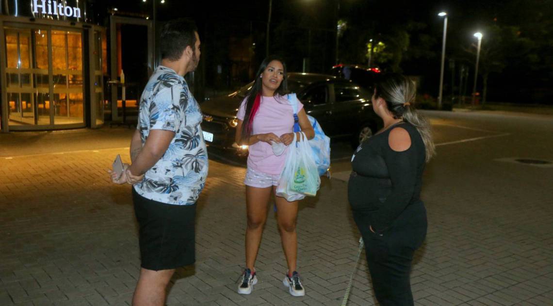 Flay chega ao hotel de máscara e posa com fãs