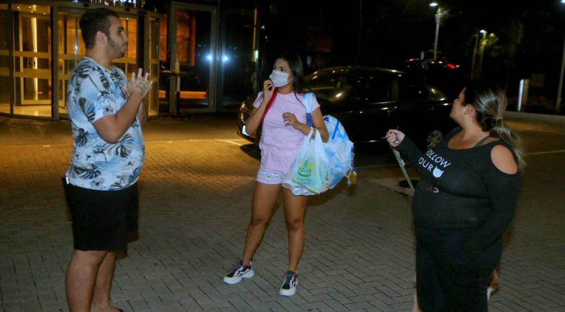 Flay chega ao hotel de máscara e posa com fãs