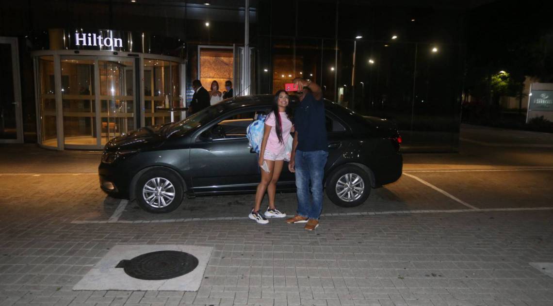 Flay chega ao hotel de máscara e posa com fãs