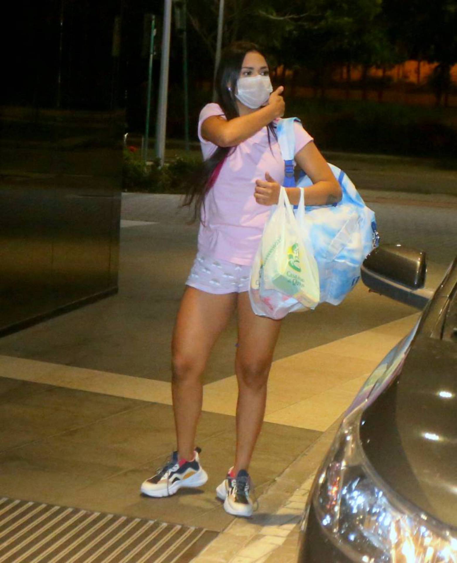 Flay chega ao hotel de máscara e posa com fãs