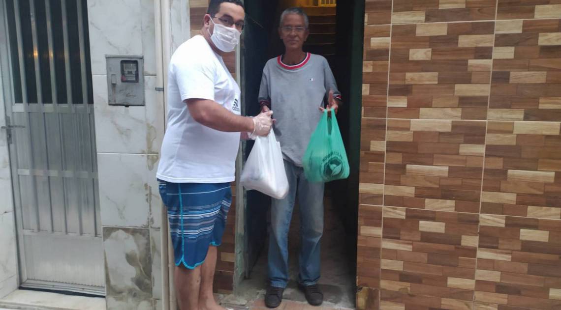 Diego Henrique retira doação na porta da casa de Celson Morais, de 58 anos, em São Cristóvão