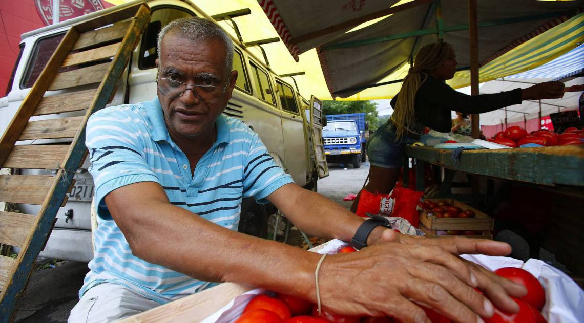 Rio - 15/04/2020 - COVID 19 - CORONAVÍRUS - HEROIS DA PANDEMIA - OS FEIRANTES - Movimentação de pessoas e feirantes na Feira Livre Silva Teles no Andaraí. Feirantes reclamam muito da queda de vendas no local e o aumento do preço de alguns produtos no CEASA. Na foto o sr. Jose Raimundo Filho com as maos nos tomates. Foto: Daniel Castelo Branco / Agencia O Dia - - - 