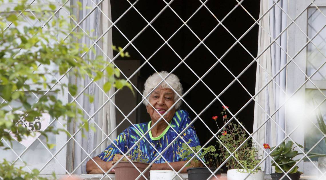 Rio de Janeiro - RJ  - 16/04/2020 - COVID 19 - Coronavírus na cidade do Rio - Na foto, Senhora em isolamento social, observa da janela de casa o movimentação na rua, próximo a Praça do Chafariz, em Madureira, zona norte do Rio - Foto Reginaldo Pimenta / Agencia O Dia