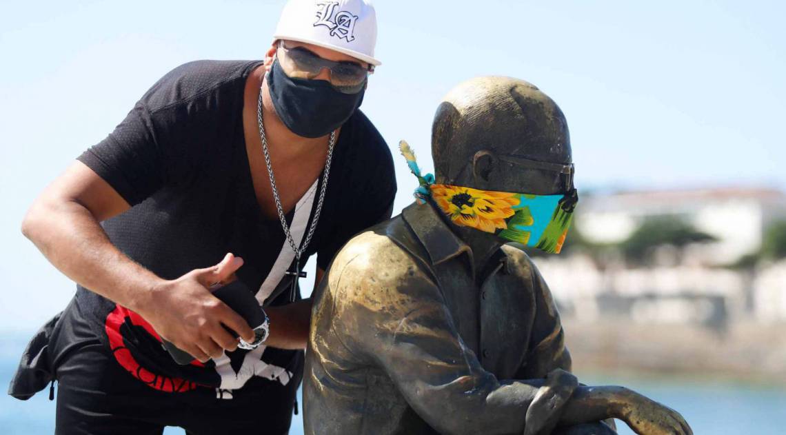 Rio, 23/04/2020  - COVID 19 - CORONAVIRUS - Estatuas em diversos pontos da cidade com mascara no rosto, na foto Lennon faz uma foto ao lado de Carlos Drumond, coronavirusrio. Foto: Gilvan de Souza /Agencia O Dia