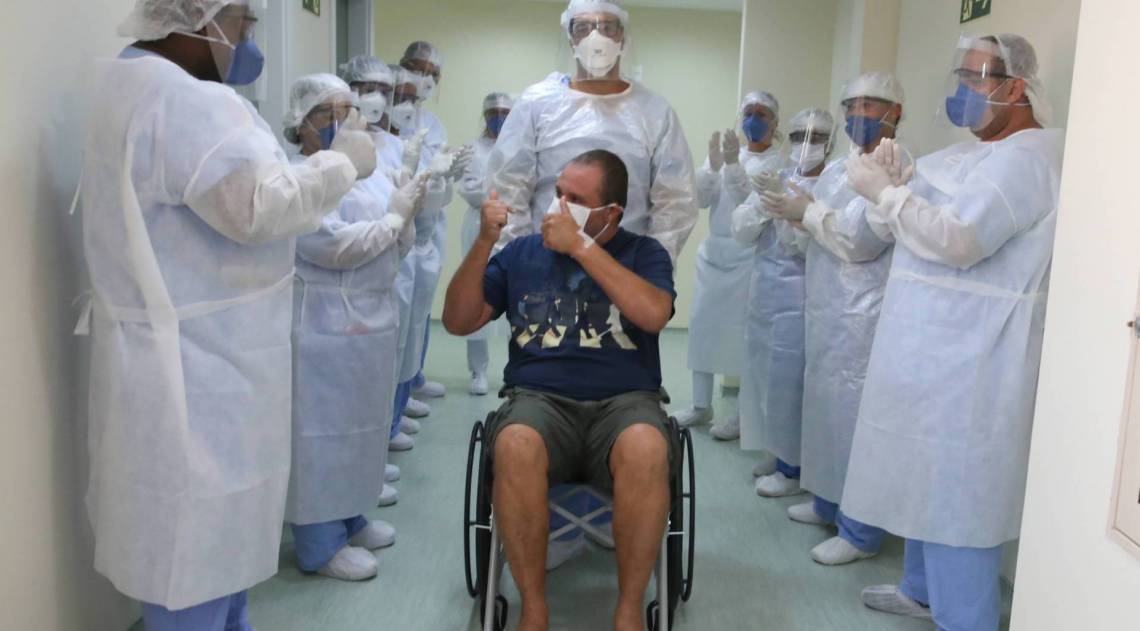 Alexandre Chagas, que chegou há sete dias em estado grave e quase precisou ser entubado, recebe o carinho da equipe no momento de sua alta hospitalar, já curado - xxxx