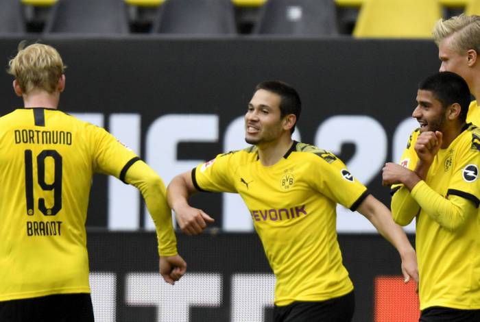 Dortmund's Portuguese defender Raphael Guerreiro (C) celebrates with Julian Brandt (L) after scoring his side's second goal during the German first division Bundesliga football match BVB Borussia Dortmund v Schalke 04 on May 16, 2020 in Dortmund, western Germany as the season resumed following a two-month absence due to the novel coronavirus COVID-19 pandemic. (Photo by Martin Meissner / POOL / AFP) / DFL REGULATIONS PROHIBIT ANY USE OF PHOTOGRAPHS AS IMAGE SEQUENCES AND/OR QUASI-VIDEO