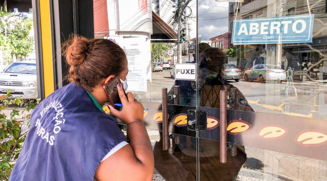 Fiscal da Superintend&ecirc;ncia de Posturas observa loja que desrespeitou o decreto do lockdown e abriu nesta segunda, em Campos
