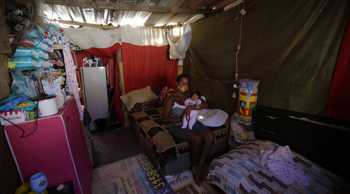 Rio de Janeiro 21/05/2020 - Covid-19 - Os proprios moradores fazem a dedetização da comunidade Jesuitas em Santa Cruz. Na foto acima a moradora Joilma Freitas com sua filha no colo. Foto: Luciano Belford/Agencia O Dia - Luciano Belford/Agência O Dia