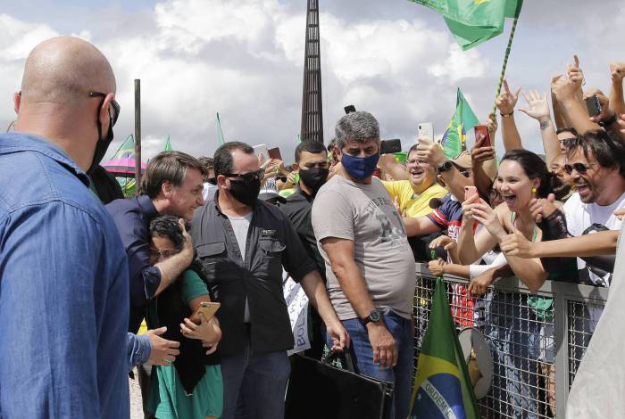 Sem máscara, o presidente Jair Bolsonaro abraça uma criança durante ato em apoio ao governo