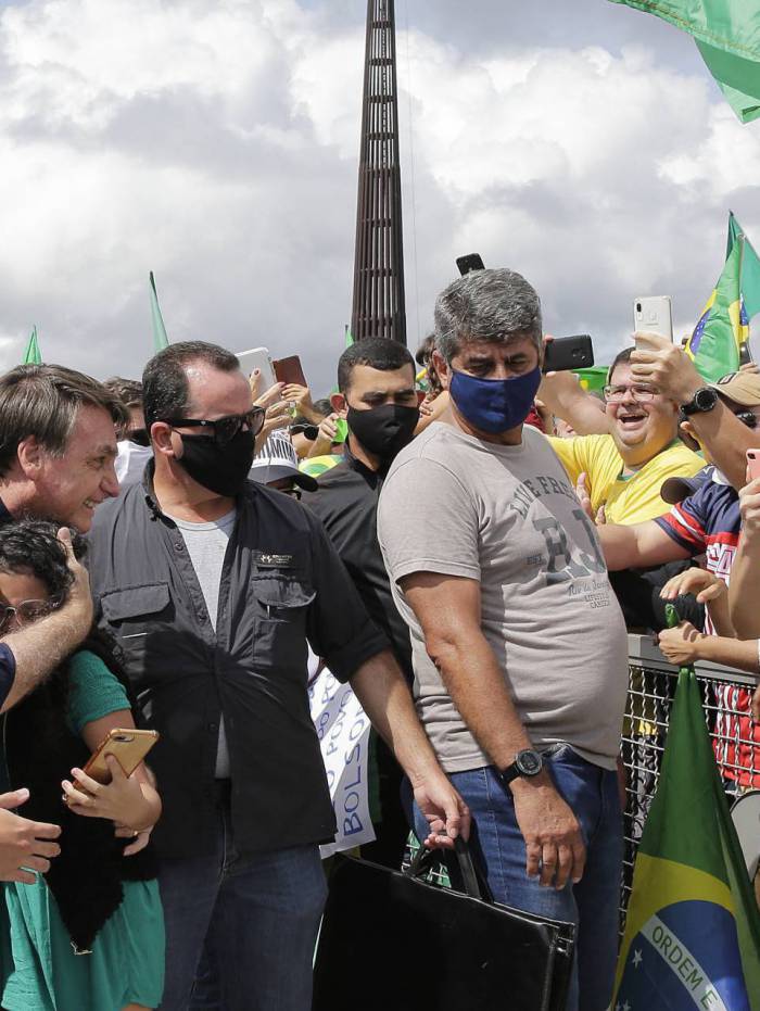 Sem máscara, o presidente Jair Bolsonaro abraça uma criança durante ato em apoio ao governo