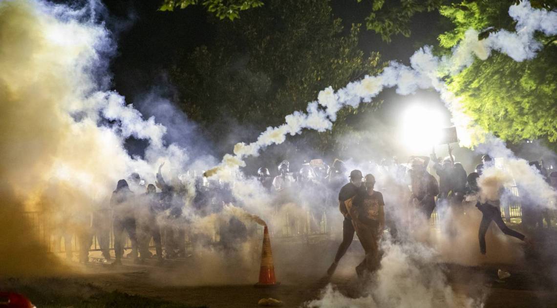 G&aacute;s lacrimog&ecirc;neo sobe &agrave; medida que os manifestantes se defrontam com a pol&iacute;cia durante uma manifesta&ccedil;&atilde;o fora da Casa Branca pela morte de George Floyd 