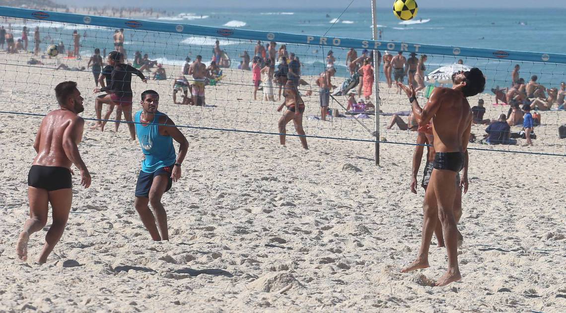 Banhistas jogando v&ocirc;lei na praia