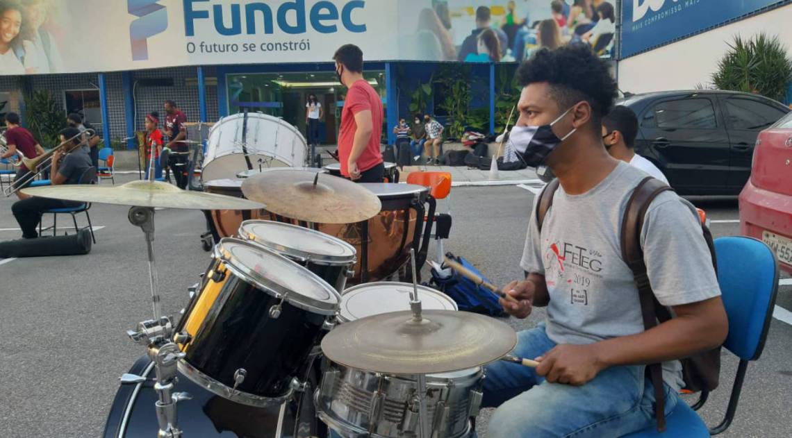 Alunos de música da Fundec assistem aula em estacionamento